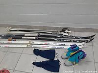 Photo showing the overall set including skis, poles, boots and gaiters arranged on the floor.