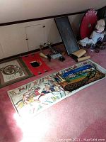 Group shot of tapestries, statue, horns with stands, cups and brass rubbings on carpet