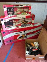Three boxed Yiboo RC helicopters (UJ405, UJ301, UJ300) stacked, plus small box with unboxed helicopter and accessories