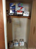 Photo of boxed computer hardware and software components on wooden shelves including CD-ROM drives and external kit boxes.