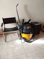 Lot contents showing black vinyl chair, Shop-Vac, and dehumidifier grouped together