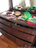 Overhead view of dresser top with Boy Scout bandannas, patches, badges, and a vintage mess kit laid out for display.