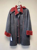 Front view of black sheepskin coat with burgundy shearling collar, cuffs, and toggle button closures hanging on hanger.