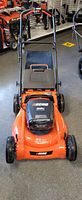 Front view of Echo orange and black cordless mower on showroom floor