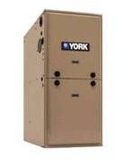 Front view of tan-colored York gas furnace model TM9V060 showing York logo on steel cabinet