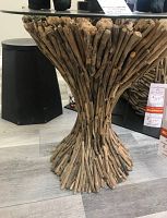 Front view of the driftwood base and glass top table in showroom.