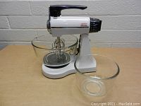 Side view of the vintage white and black Sunbeam Mixmaster stand mixer with glass mixing bowls