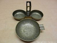 Front view of the larger ashtray showing the embossed leaf pattern in the bowl and dual compartments with matchbox holder