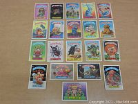 Top-down image showing the entire spread of 22 Garbage Pail Kids cards arranged in 4 rows, displaying the card art and titles clearly.