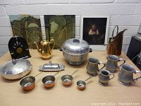 Wide view of all vintage kitchenware and pictures arranged on table with white wall background