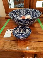 Two floral ceramic bowls on wooden surface. Large bowl with 6 marble eggs inside and smaller bowl placed in front.