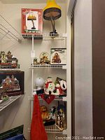 Photo showing Christmas decorations on wire shelving including the leg lamp, snow globes, and figurines.