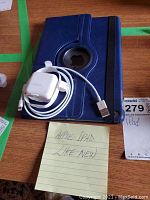 Blue rotating folio case, coiled USB-A to Lightning cable, power adapter and handwritten note