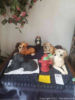 Full view of six dog figurines and fire hydrant on dark blue cloth