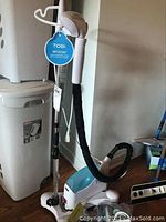 Photo of Tobi standing garment steamer showing upright design with blue water tank and hose.