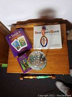 Overview on wooden table showing three boxed tarot items and glass orb paperweight
