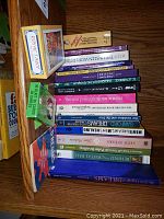 Books and two tarot card decks on a shelf from an angled view showing titles and both boxes