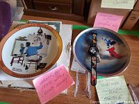 Photo showing the Norman Rockwell collector plate, the Mickey Mouse Fantasia plate, and the Bugs Bunny watch with labels identifying each item.