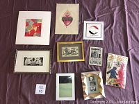 Overview of nine pieces including paintings, framed photos, vintage postcard, voodoo kit, and mixed media artworks on fabric and paper.