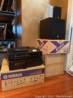 Photo showing stack of electronics on Yamaha boxes including Onkyo CD player, Yamaha receiver and speaker boxes