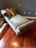 Full front-angle view of chaise lounge with pillows on hardwood floor.