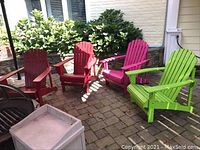 Group shot of four Adirondack chairs on patio in green, pink, and red