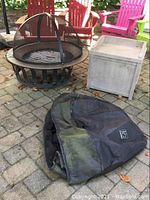 Fire pit, protective cover, and Suncast storage box arranged on patio pavers