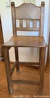 Front view of one solid wood Ipe bar stool showing backrest, seat, and legs.