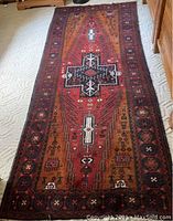 Full view of oriental wool runner carpet showing geometric central medallion and border motifs