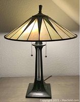 Frontal view of lamp illuminated, showing shade pattern and base design