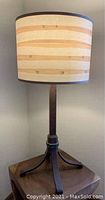 Full view of wrought iron table lamp with bamboo patterned fabric shade and copper banding