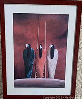 Framed painting showing three Native American figures from behind in cloaks and feather headdresses, set against a reddish-brown background.