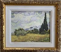 Photo of canvas print of Vincent van Gogh French countryside painting in an ornate gold frame with white matting.