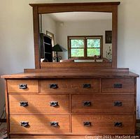 Full view of 7-drawer oak dresser with mirror attached. Visible metal bail pulls and quarter-sawn grain.