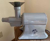 Photo of Champion Juicer showing side profile, feeding chute, and pulp outlet.