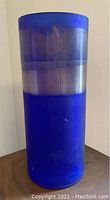 Front view of blue and silver Venetian glass vase on wooden surface