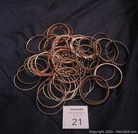 Pile of various hoop bracelets showing different sizes, colors and designs
