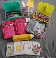 Photo showing all items in the lot: multiple pencil cases in green, yellow, pink, and silicon pencil shape; bundled pens, pencils, stickers, and calculator