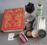 Photo showing all items laid out, including the red decorative BareMinerals Storybook Romance box, battery operated brush cleaner, shampoo bottle, makeup brushes, eyelash curler, eyebrow tint, mascara, primer, cheek colors, and cosmetic jars.