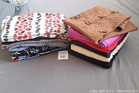 Photo of 12 folded women's skirts and skorts in various colors and prints, showing the variety and quantity of items included.