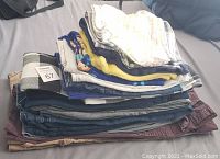 Stack showing 17 pieces of assorted women's pants, jeans, and shorts in various colors and styles.