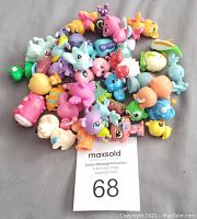 Top view of multiple Littlest Pet Shop figurines clustered together mostly animal characters in bright colors.