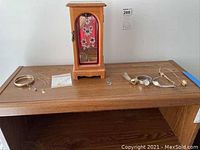 Overview of wooden jewelry box, bangle, necklaces and watches on shelf