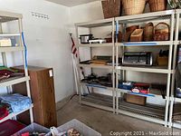 Four beige plastic shelving units with various household items on shelves; shelving stained and worn.