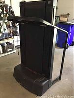 Side view of the black Pro Form EKG treadmill folded, showing the handlebar and treadmill belt unit, along with storage configuration.