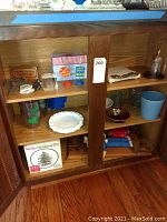 Shelf with multiple glassware and decor items including Spode Christmas Tree wine glass box, plastic cups, coasters, and assorted small decor items