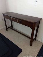 Full view of the wood foyer table showing the overall shape and condition.