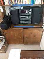 Full view of the Kenwood XD-500 component system with two speakers and Panasonic radio cassette deck next to it on a wooden surface under a bookshelf.