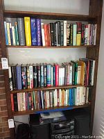 Six shelves of books including reference texts, fiction, biographies
