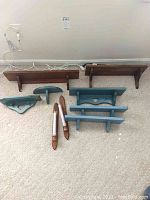 Seven wood wall-mounted shelves in blue and natural wood finishes, various sizes